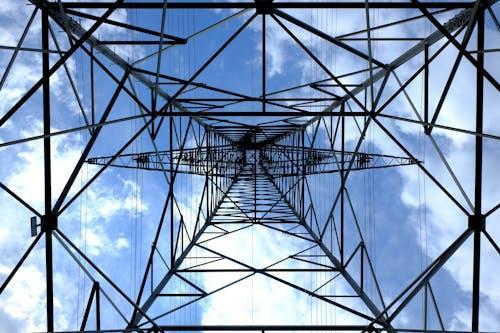 Free Looking up at a steel power pylon against a bright blue sky. Stock Photo