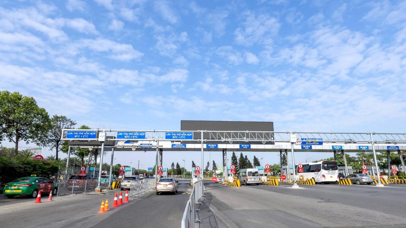 A highway with cars and a sign on itDescription automatically generated