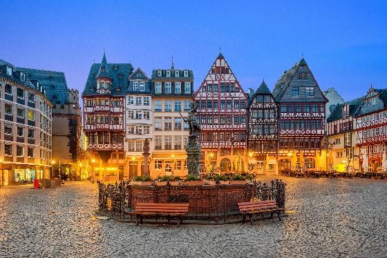 A group of buildings with a fountain in front of themDescription automatically generated