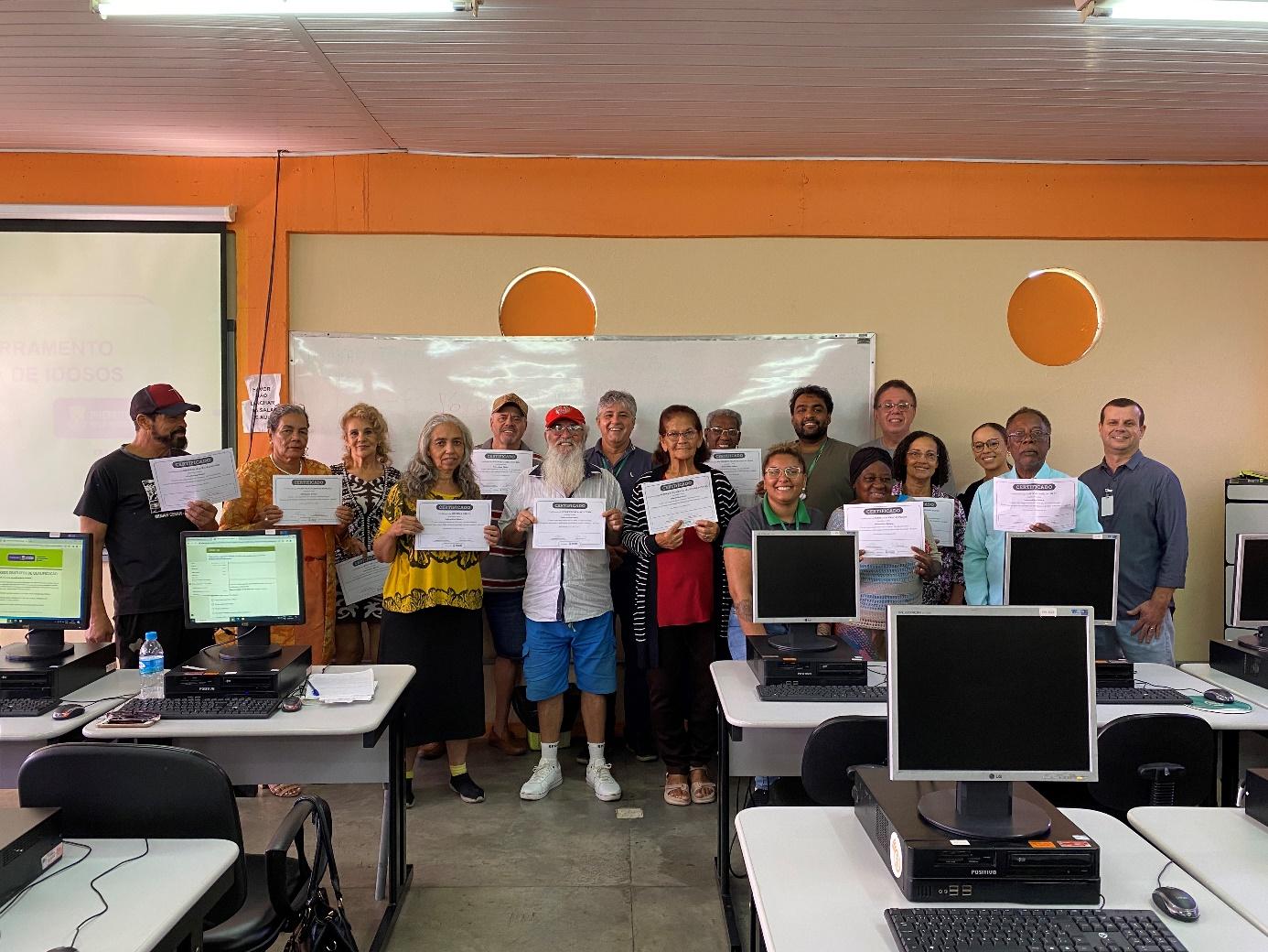 A group of people holding signs in a classroom</p>
<p>Description automatically generated