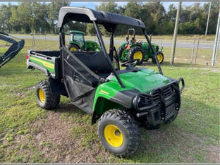 A 2025 John Deere Gator HPX 615E parked on a grassy lot.