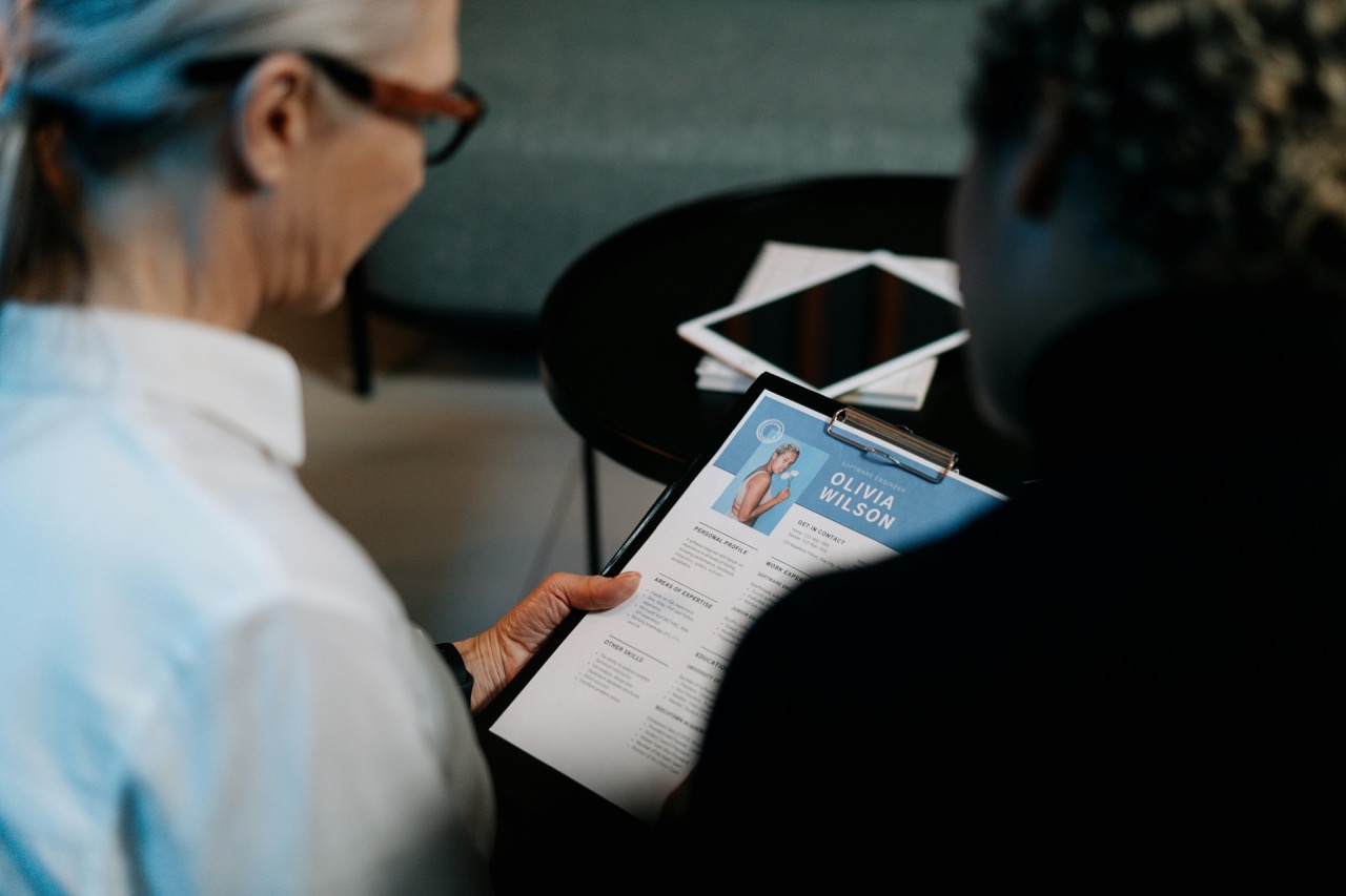 Close-up of a resume being evaluated by two individuals in a professional office setting.