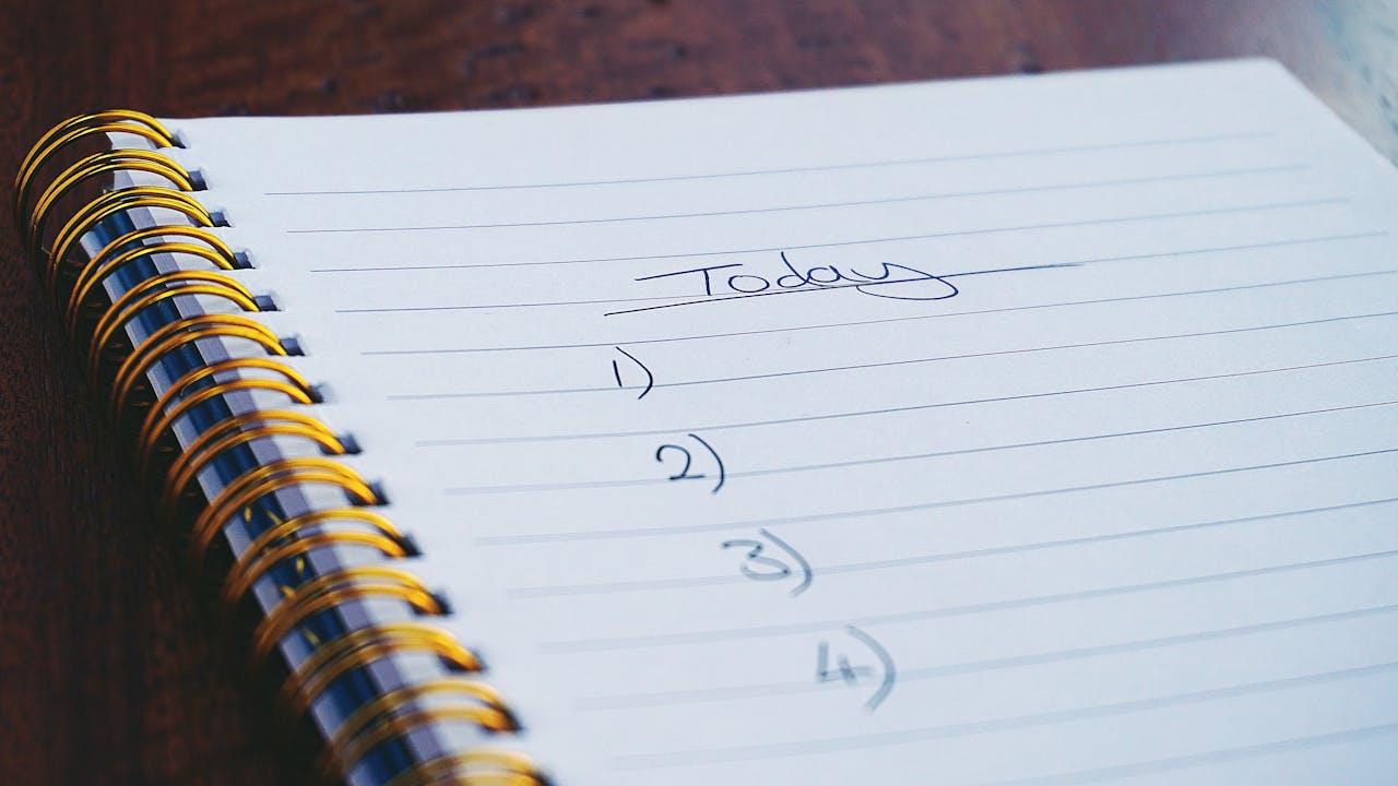 A notepad displaying a neatly written to-do list, ready for tasks to be checked off.