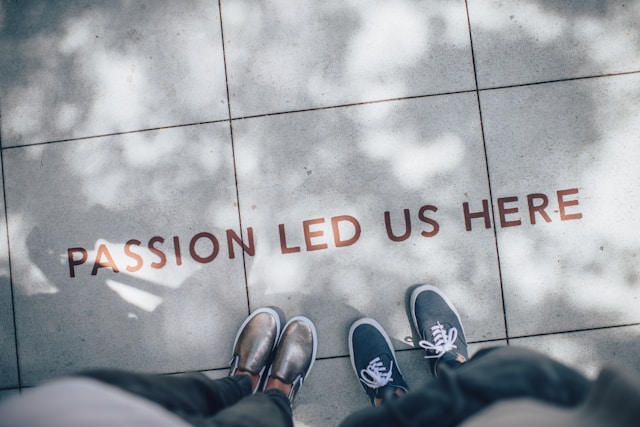 Two persons standing infront of the word "Passion led us here"