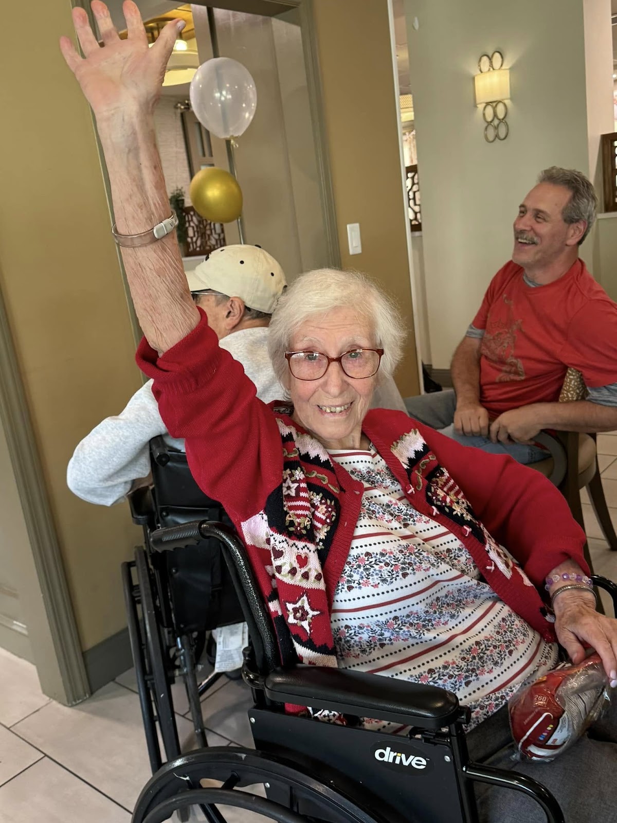 A woman engaging in an independent living activity and smiling with her hands up