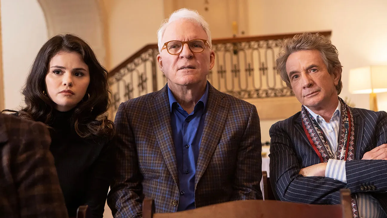 Escena de la serie 'Only Murders in the Building' con los personajes principales interpretados por Selena Gomez, Steve Martin y Martin Short, mostrando preocupación mientras investigan un misterio.