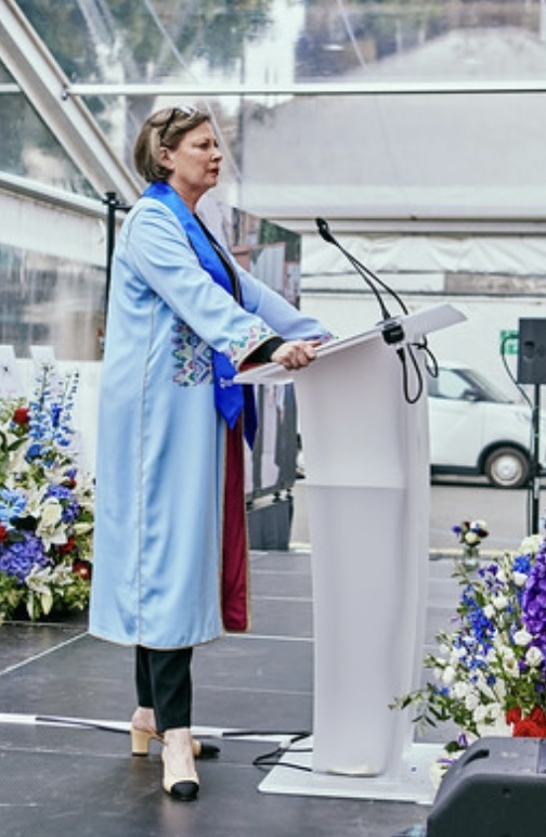 A person standing at a podium

Description automatically generated