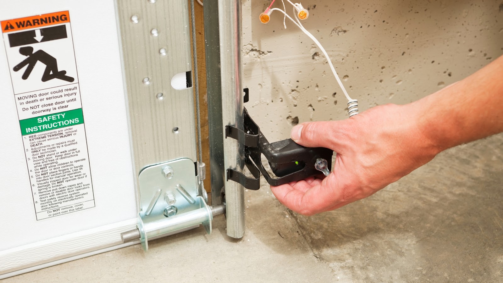 A technician adjusting the garage door safety beam