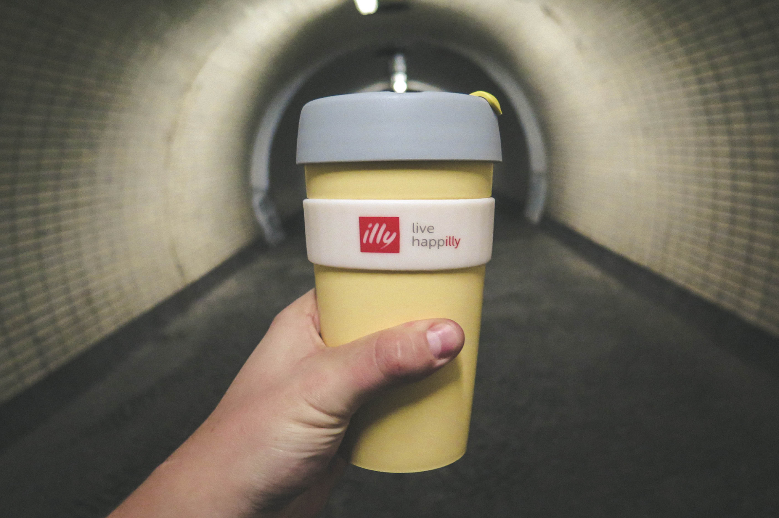 A picture showing a hand holding illy coffee mug