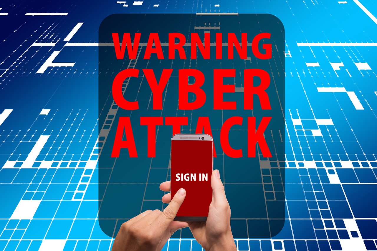 A digital image showing the warning "CYBER ATTACK" in bold red letters, with a hand holding a phone displaying "SIGN IN" against a blue digital background.