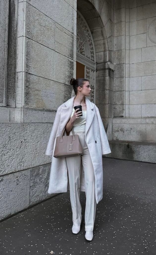 A white wool coat with a cream outfit.