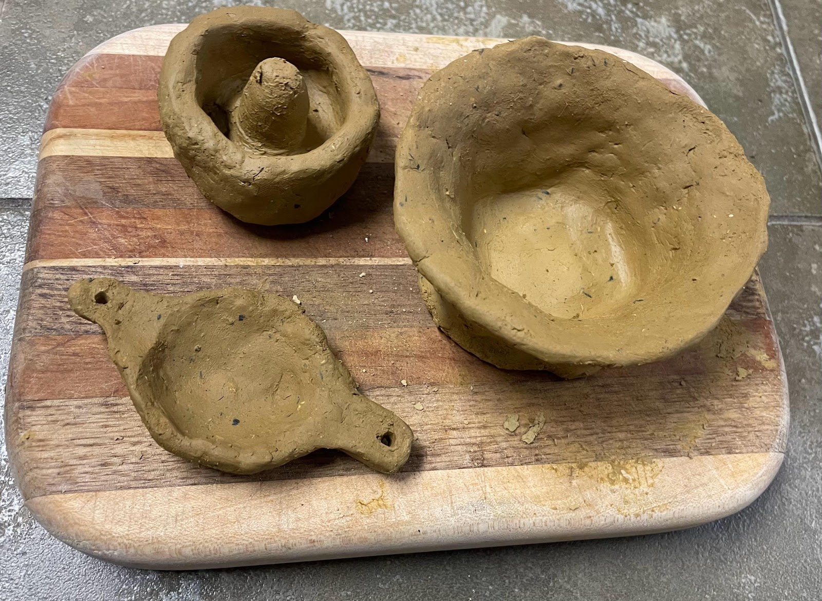 Clay bowls on a wooden board

AI-generated content may be incorrect.
