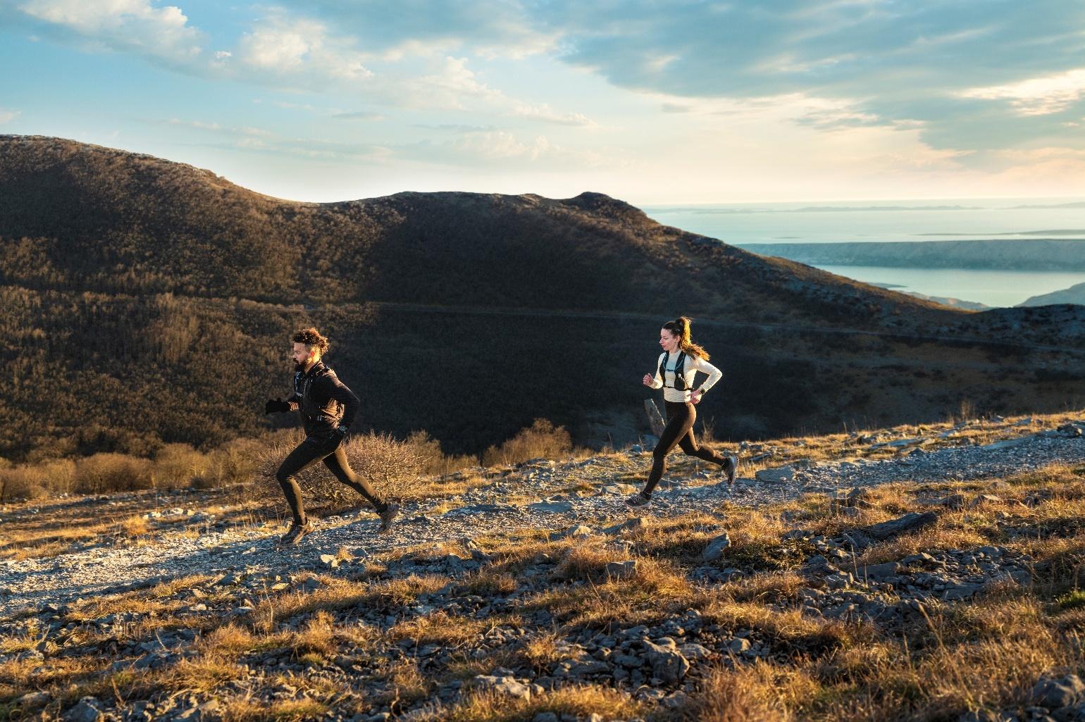 A group of people running on a rocky hill

Description automatically generated