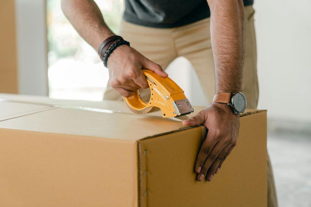 A man packing a box while following Connecticut's storage regulations 