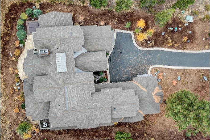 Bird's eye view of the house showing its tiled roofs and concrete driveway.