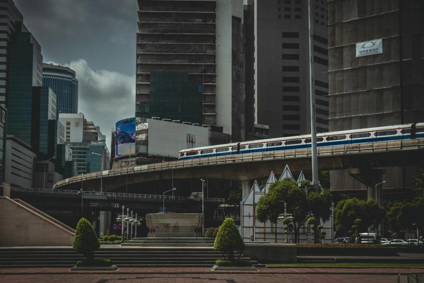 A train on a bridge in a city

Description automatically generated