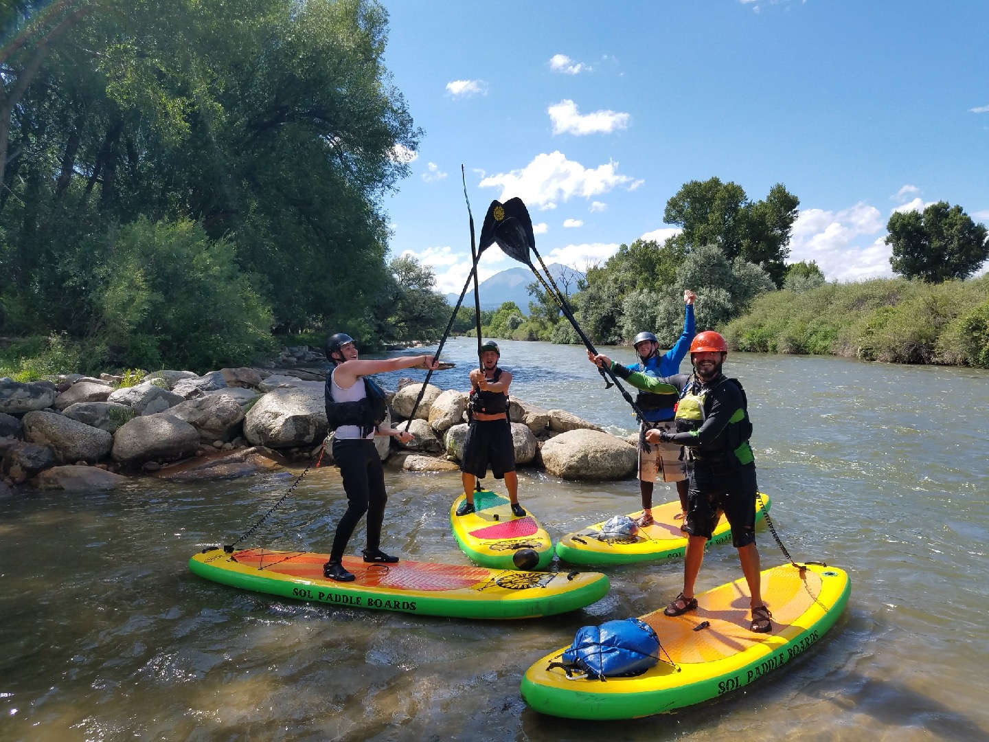 a group of people standing on paddle boards in the water 