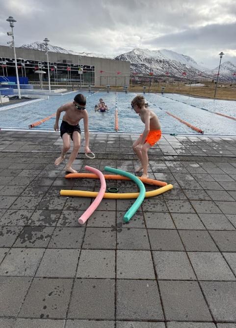 Two boys playing with pool noodles
AI-generated content may be incorrect.