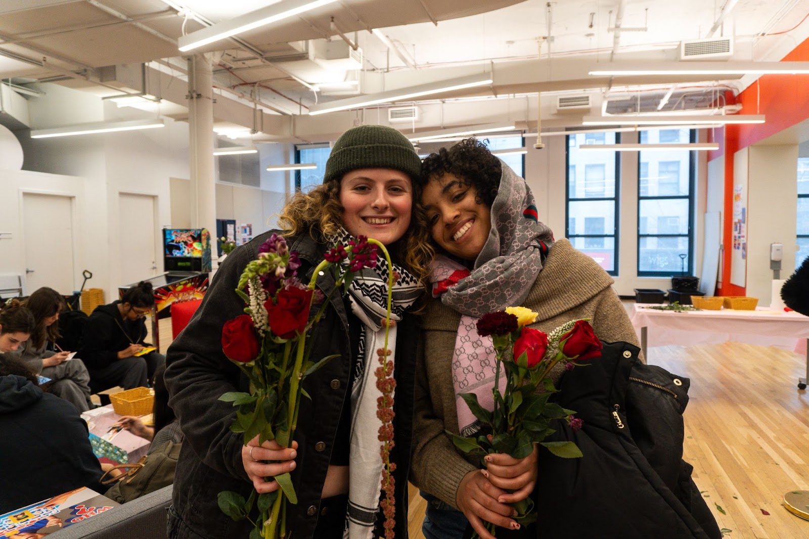 Two students pictured smiling, holding their respective bouquets.