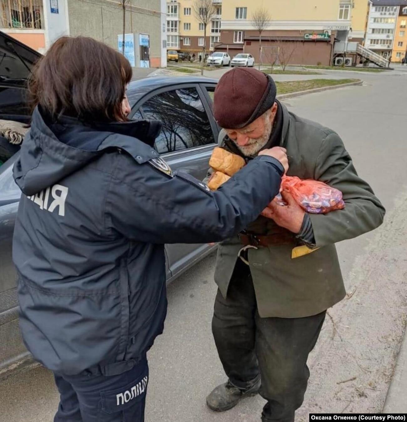 A person helping a person to get food from a car

Description automatically generated