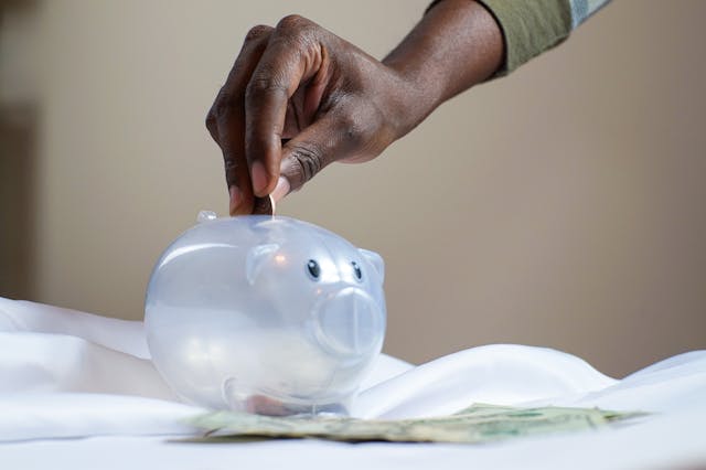 Person putting money in piggy bank