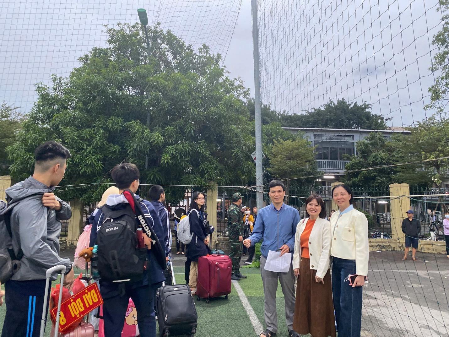 A group of people standing on a field with luggage

Description automatically generated