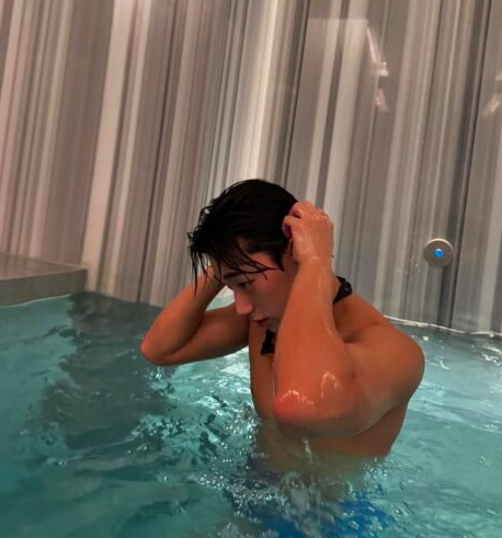 This contains an image of ATEEZ's San in a swimming pool