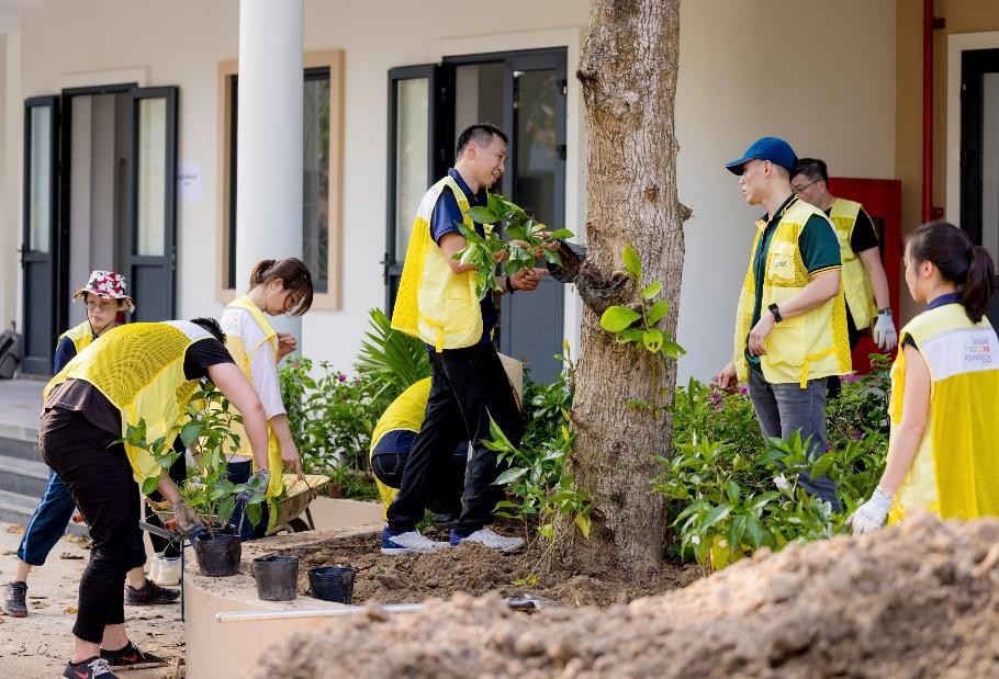 A group of people planting trees

Description automatically generated