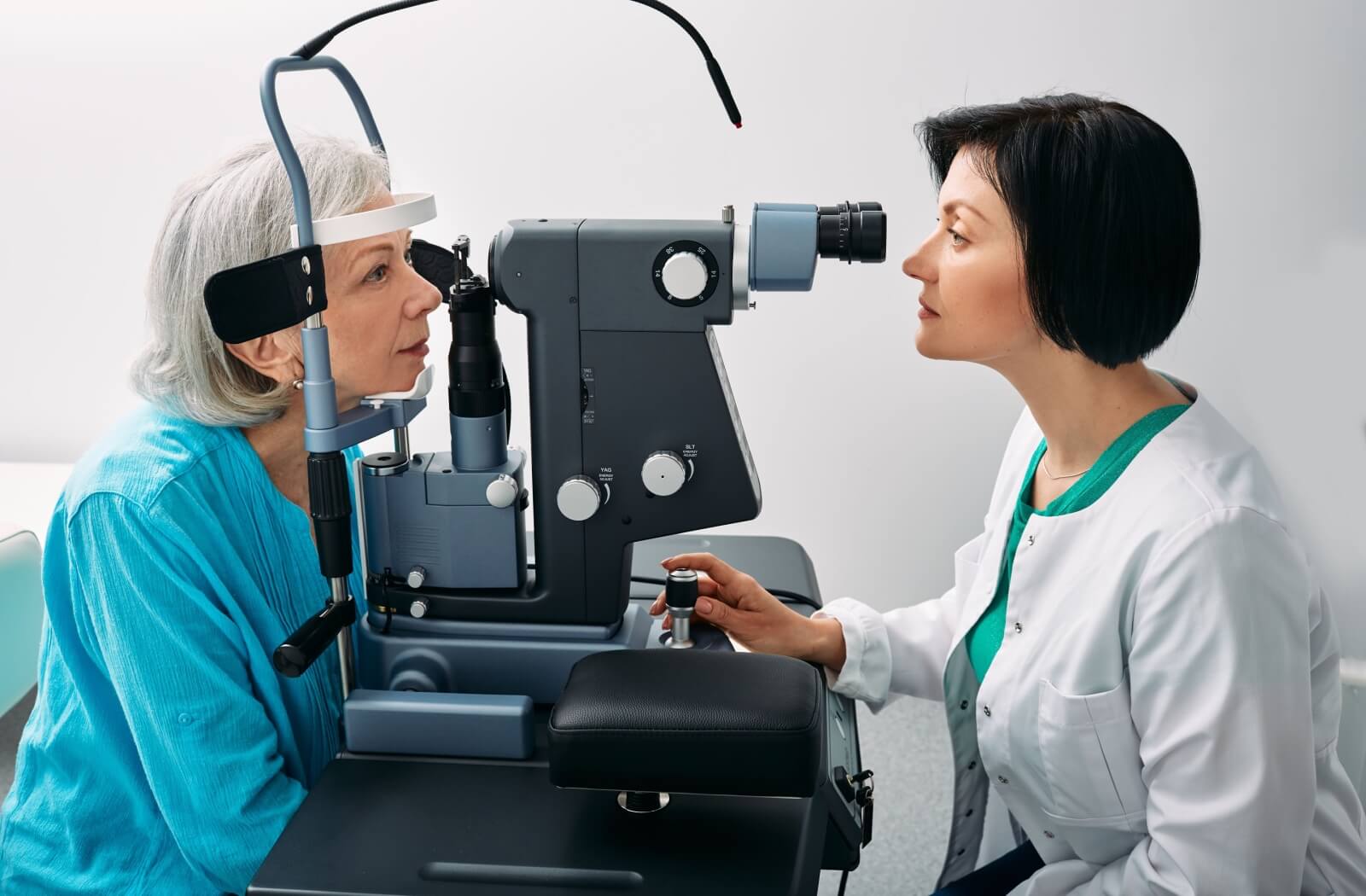 Senior woman getting an eye exam from a female optometrist