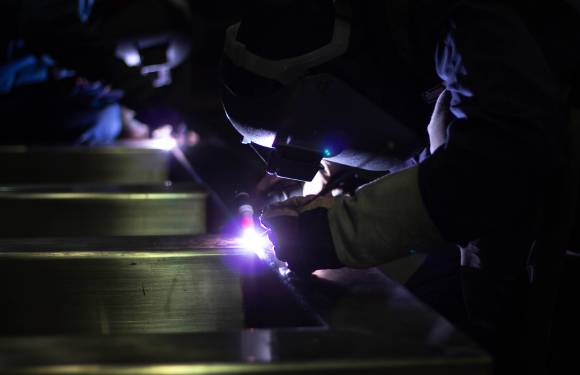 two welders in dark room