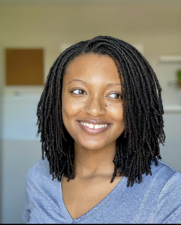 A lady smiling and showing her hairdo