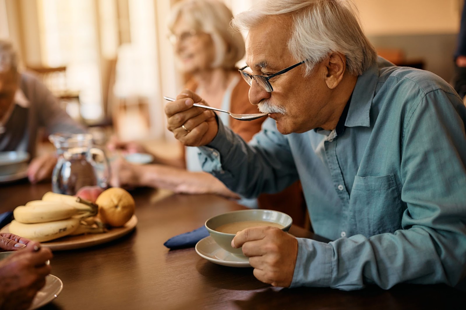 A group of seniors enjoying a meal together in a communal dining area.