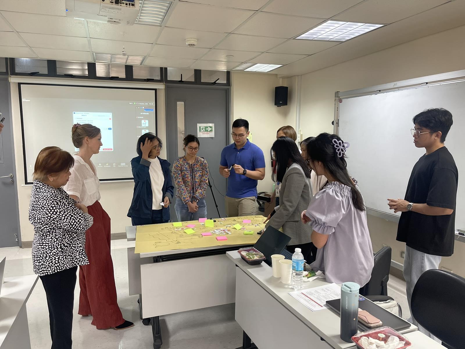 A photo of participants discussing in front of a flipchart.