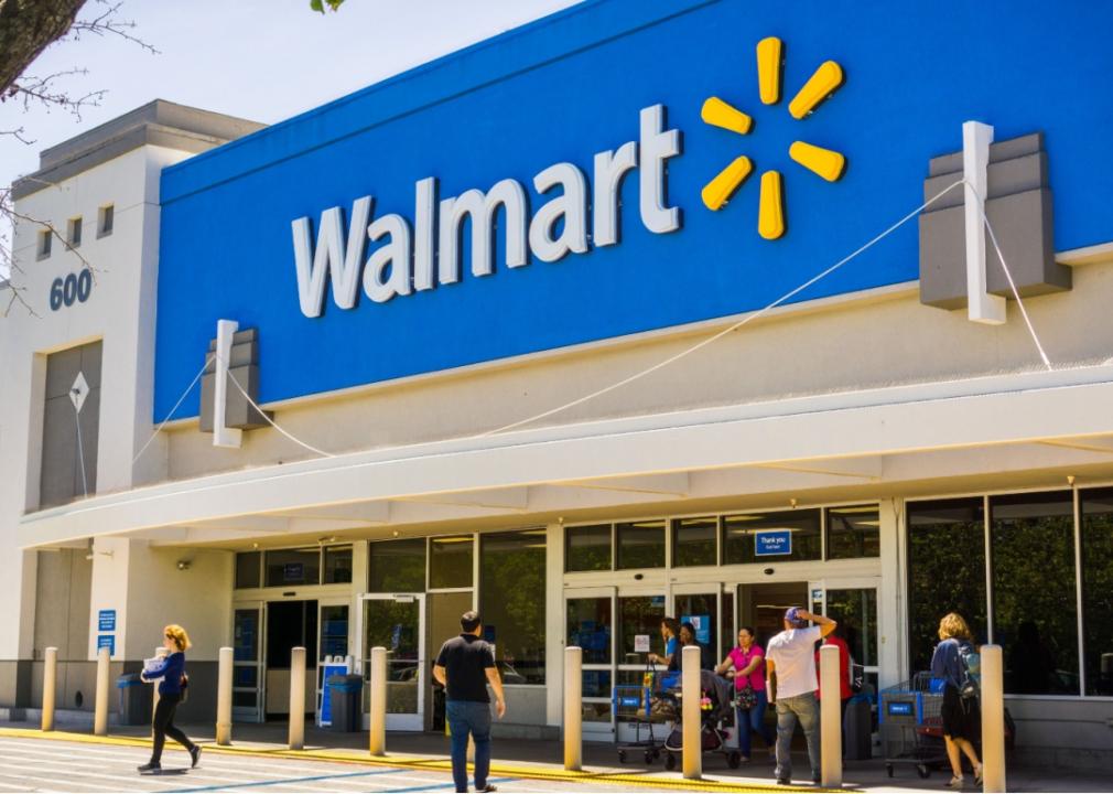 Shoppers coming in and out of the entrance of a Walmart.
