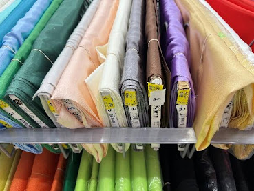 A shelf with colorful fabric rolls

AI-generated content may be incorrect.