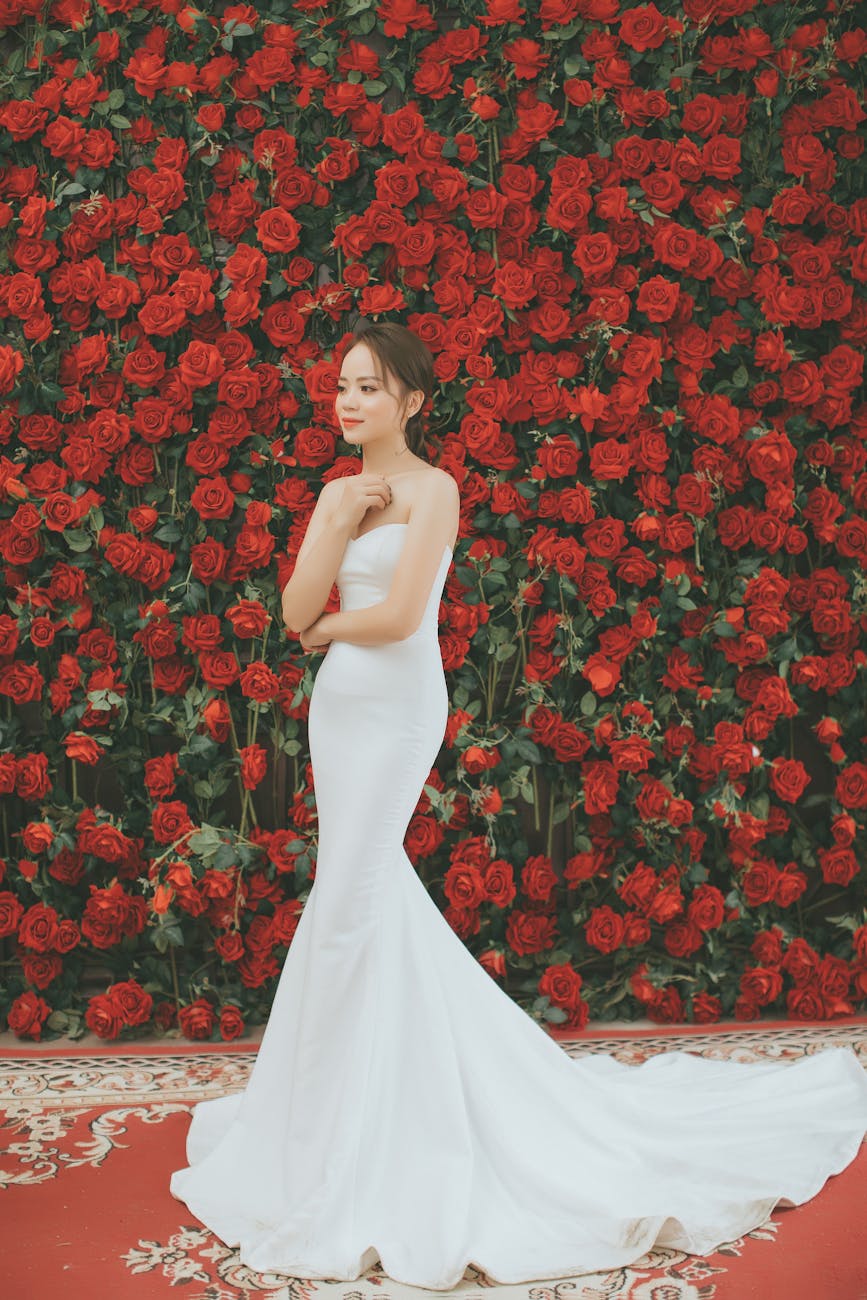 woman wearing white gown with red roses on background