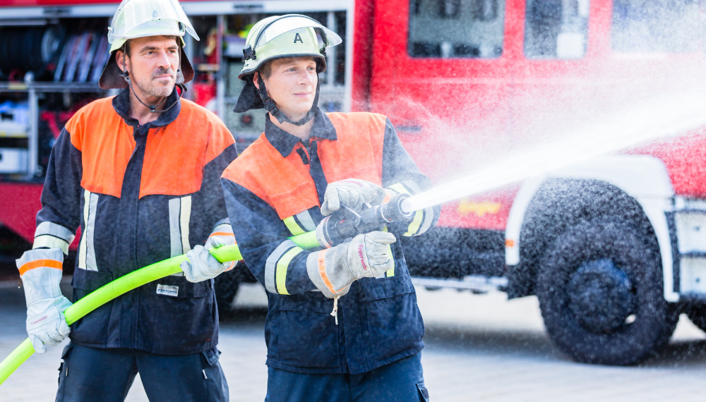 A couple of firefighters spraying water

Description automatically generated