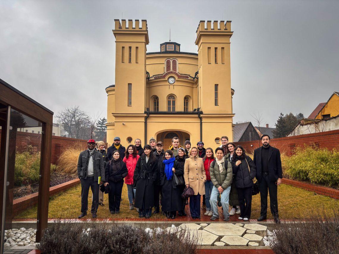 A group of people posing for a photo in front of a building

AI-generated content may be incorrect.