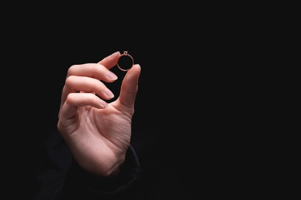 Holding diamond ring on hand