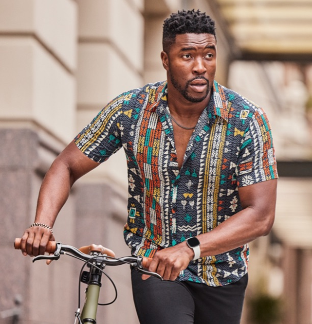 Man pushing his bicycle wearing Fitbit Sense 2 showing enduring Battery for 6+ days without stopping for a charge.