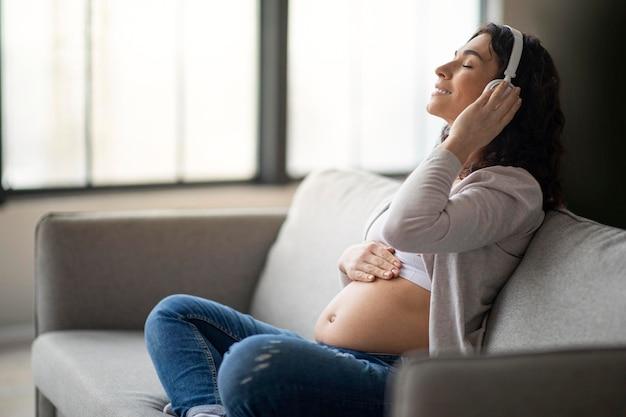 Premium Photo | Leisure during pregnancy happy pregnant woman listening  music in headphones at home