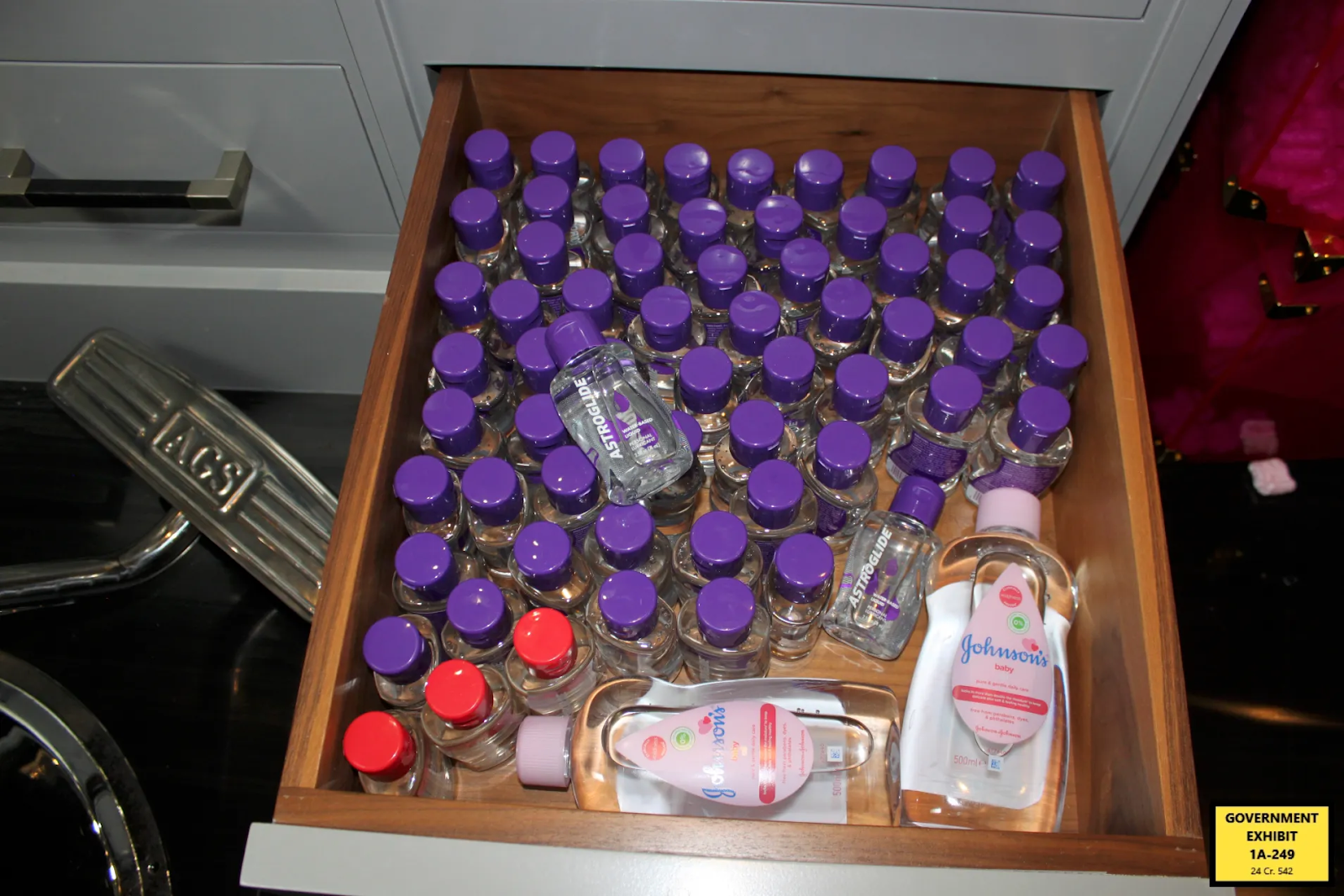 Evidence photo showing baby oil, lubricant bottles, and firearms seized during federal raid on Sean Combs’ residence.