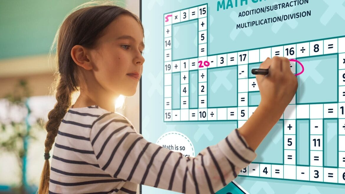 A young girl using an interactive whiteboard in the classroom