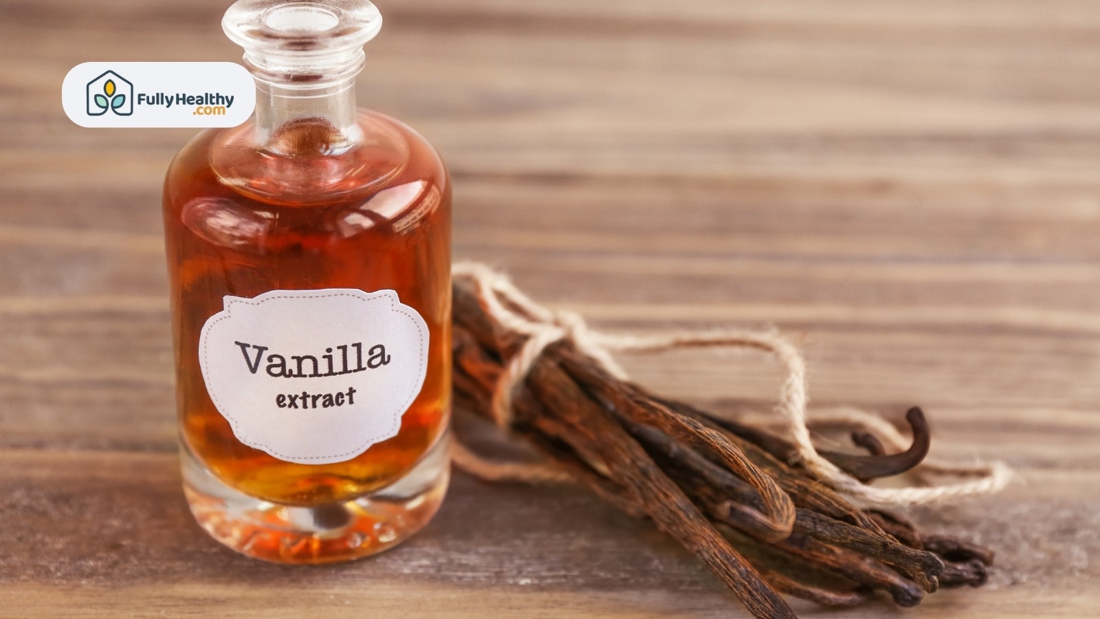 Clear bottle labeled vanilla extract with bundled vanilla beans beside
