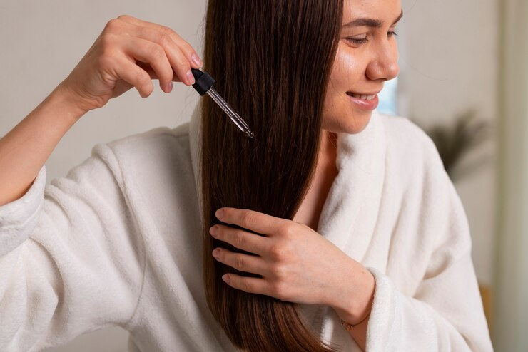 Woman applying hair serum