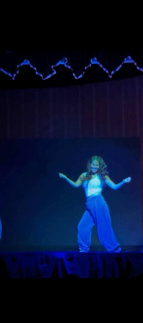 A person dancing on stage

Description automatically generated