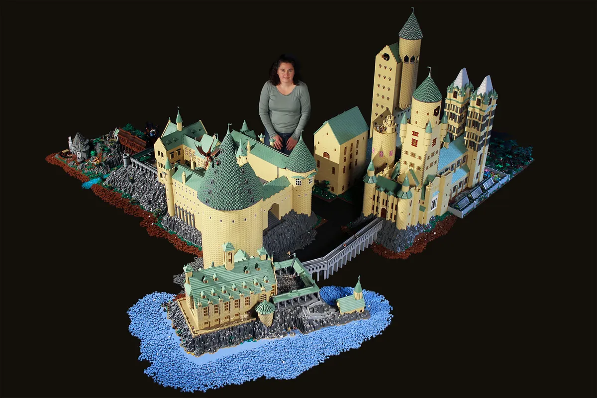 A person standing in front of a building model

Description automatically generated