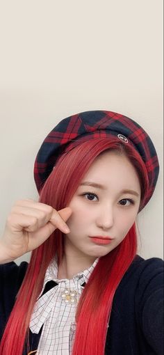 This contains an image of Lee Chaeyeon's with long red hair wearing a hat