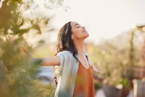 Person peaceful in a garden stretching arms, representing calm and wellness