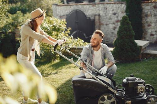 Free Woman in Brown Long Sleeve Shirt Holding Grass Cutter Stock Photo